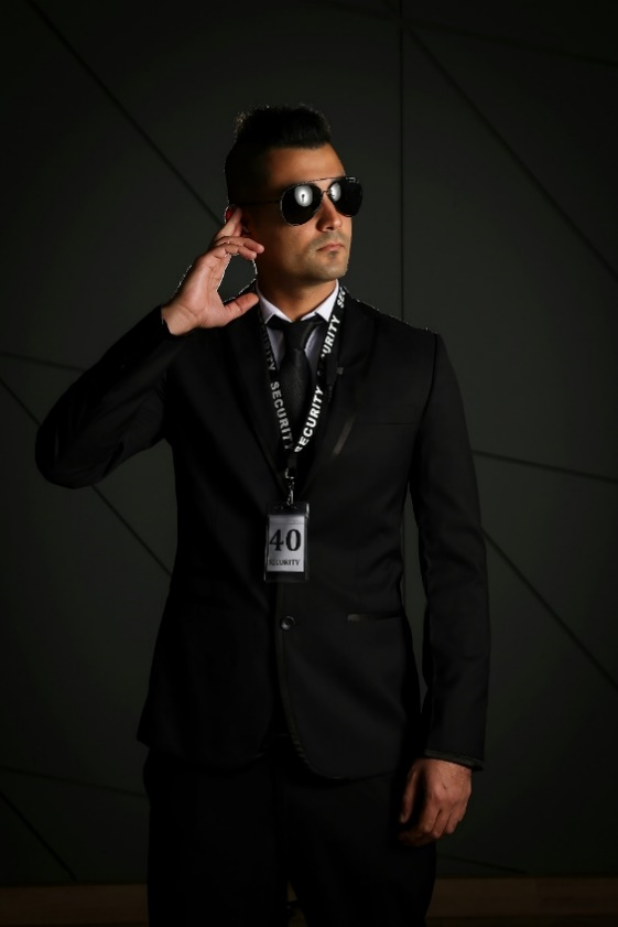 A professional security officer listening to an alert through his headpiece while on duty