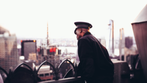  A uniformed security officer standing at the top of a commercial building scanning the surrounding area