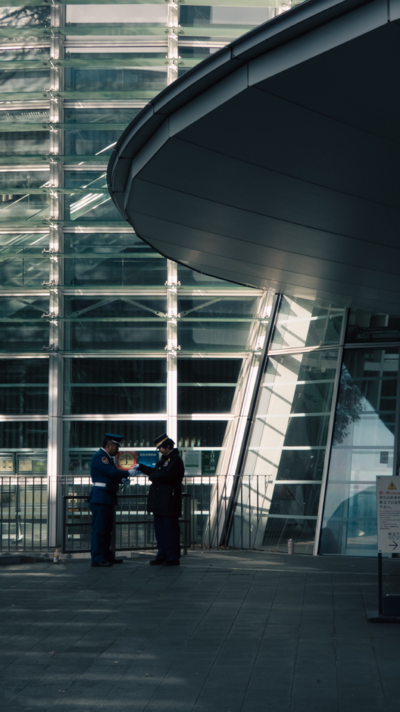 Two uniformed security officers standing guard in front of a commercial building entrance