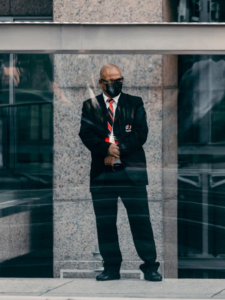 A professional security officer standing at his post outside a commercial building during his shift