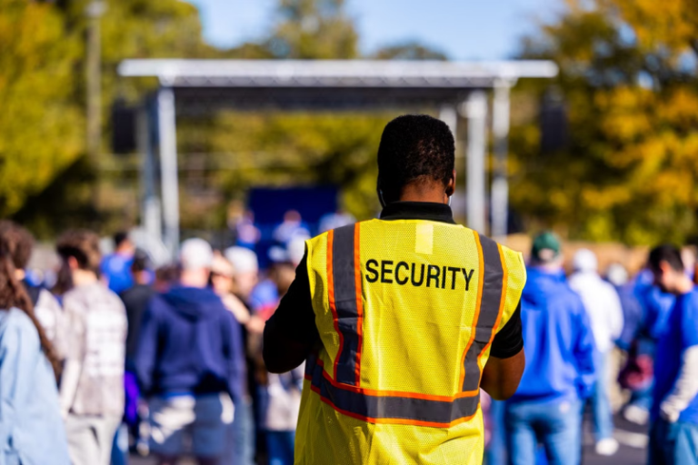 This photo shows a security guard standing outdoors.