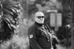 This photo shows a black and white of a security guard wearing sunglasses.