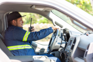 A security professional drives in a patrol car on fire watch.
